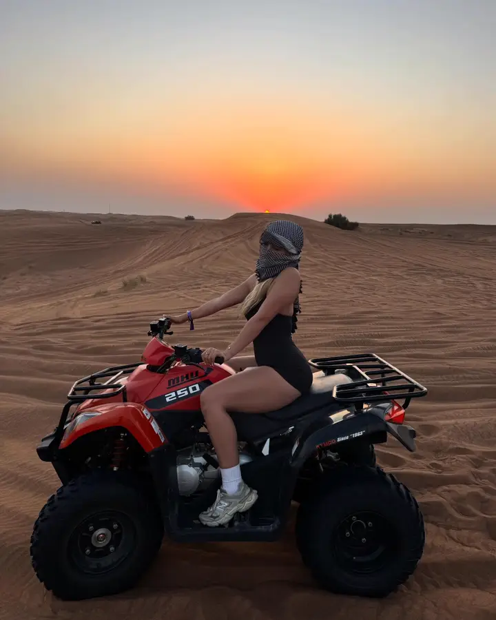 Friends quad biking on the high red dunes at sunset — Dubai desert safari guest photo 1