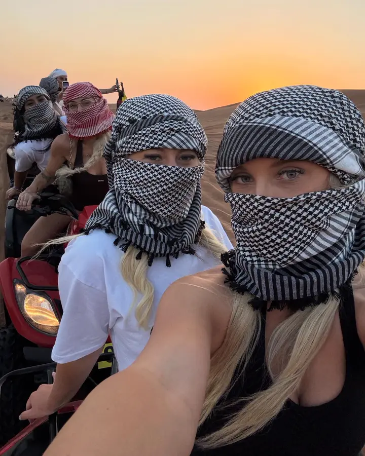 Friends quad biking on the high red dunes at sunset — Dubai desert safari guest photo 4