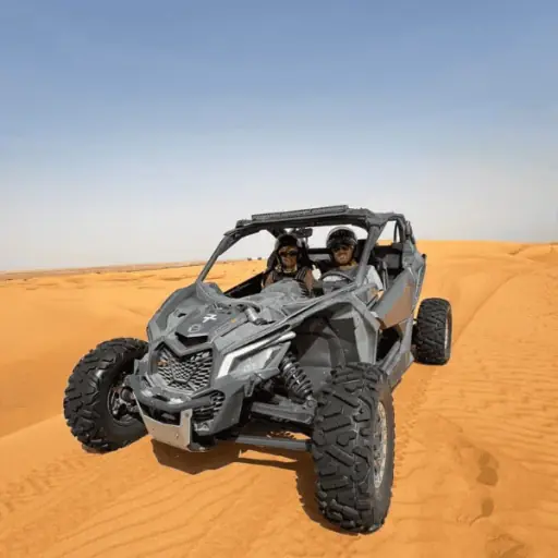 Can-Am X3 Turbo dune buggy kicking up sand on the Lahbab red dunes