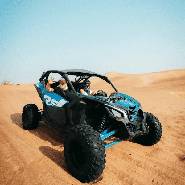 Can-Am Maverick X3 dune buggy jumping a dune in the Dubai desert