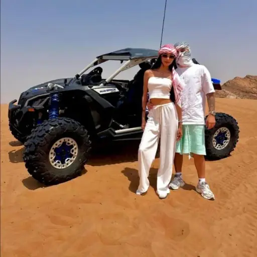 Couple in a Can-Am Maverick X3 Turbo dune buggy on Dubai red dunes