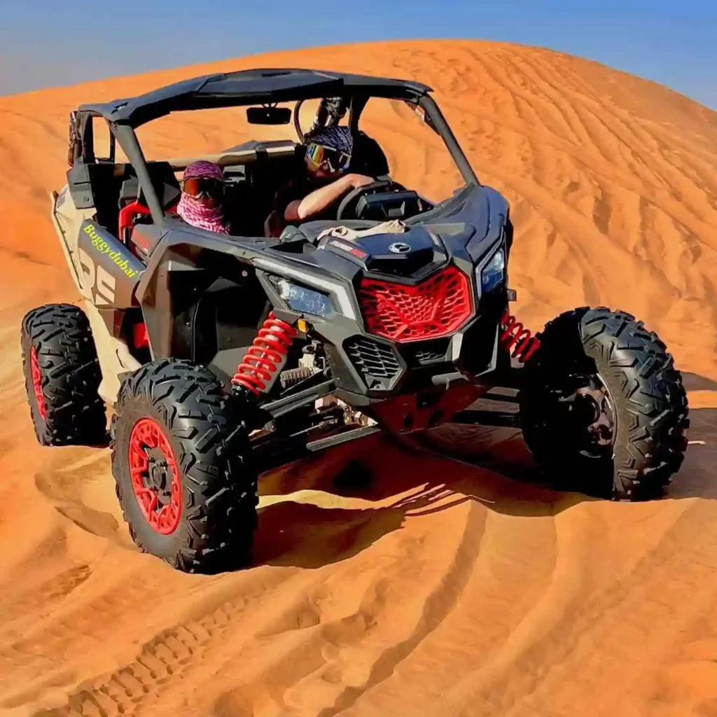Two people riding a dune buggy in the sand dunes of Dubai.